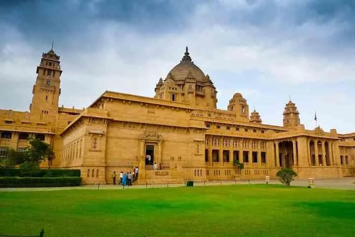 Umaid Bhawan Palast mit grüner Wiese unter bewölktem Himmel